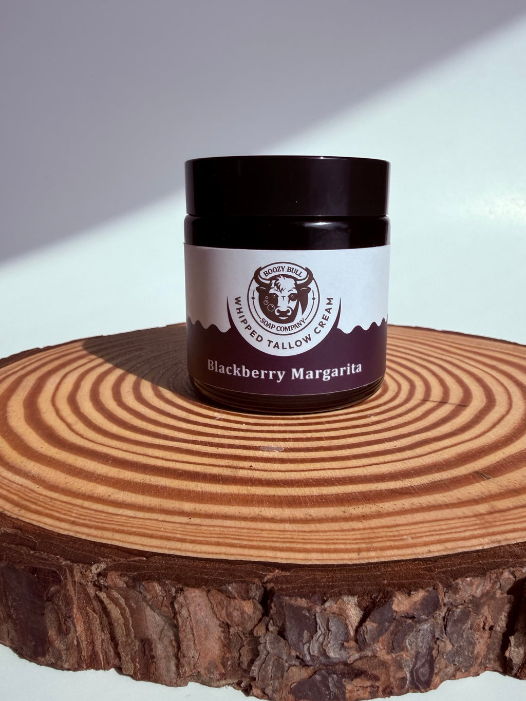 Jar of 'Blackberry Margarita' on a wooden surface with a white background