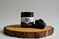 Jar of Blackberry Margarita on a wooden board with blackberries