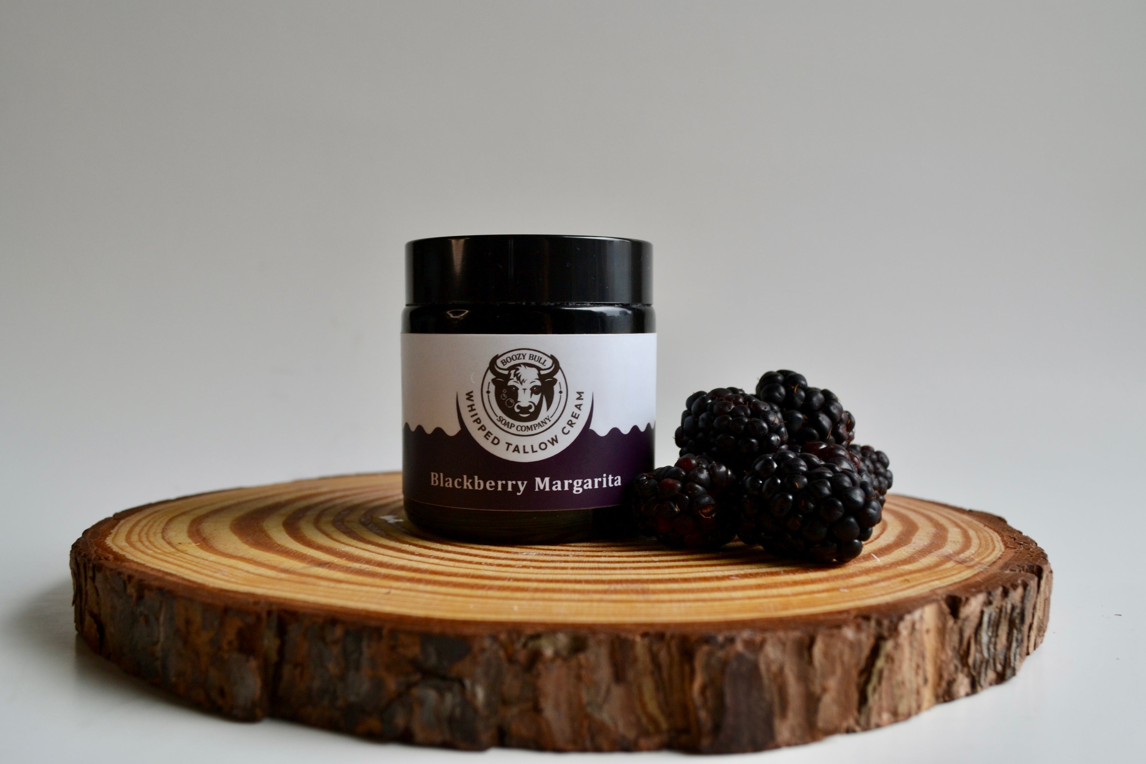 Jar of Blackberry Margarita on a wooden board with blackberries