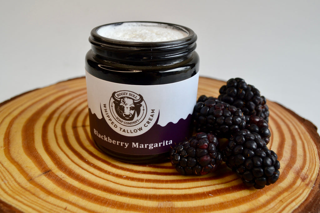 Jar of blackberry margarita cream on a wooden surface with blackberries