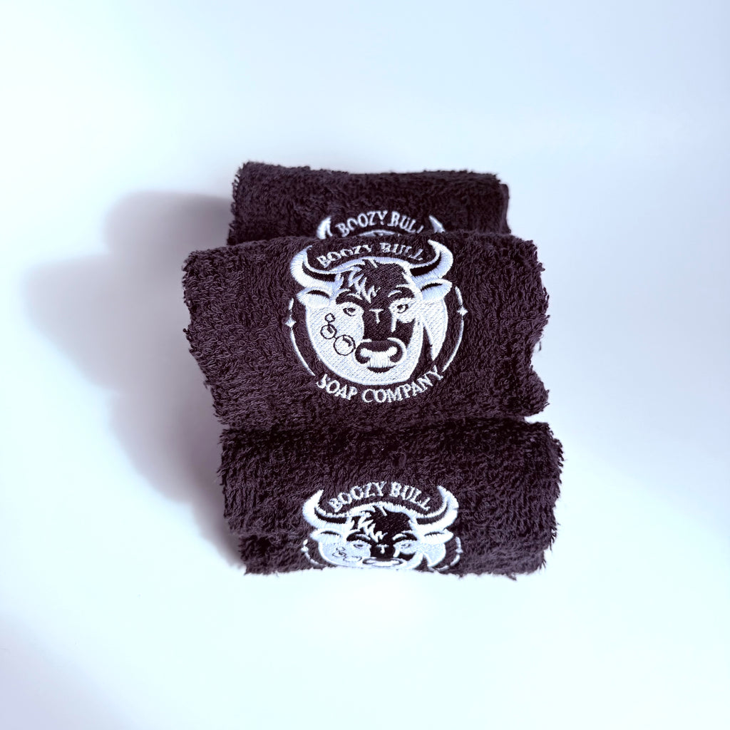 Three black towels with a white logo on a white background