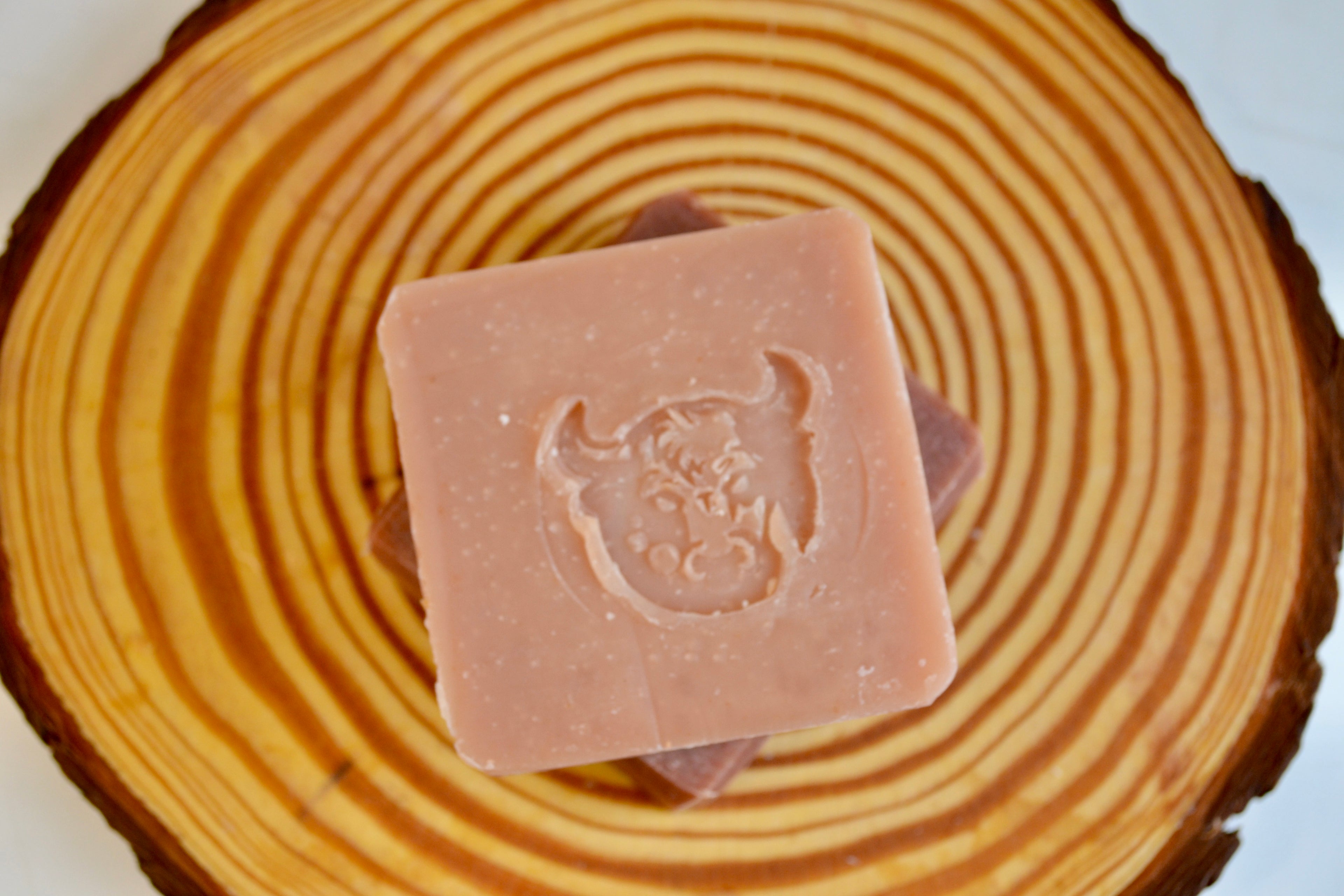 Bar of soap with a logo on a wooden surface
