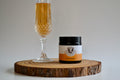 Champagne flute and bottle of champagne on a wooden board with a plain background