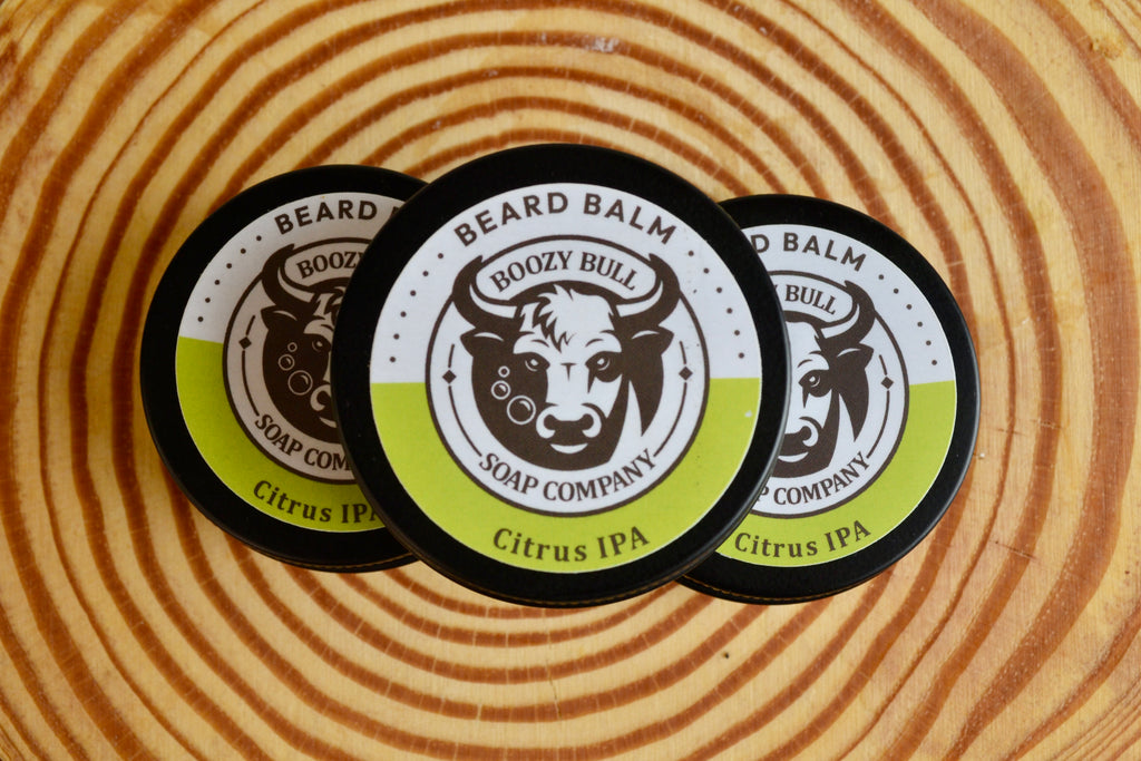 Three boozy bull Beard Balm Containers on a wooden surface