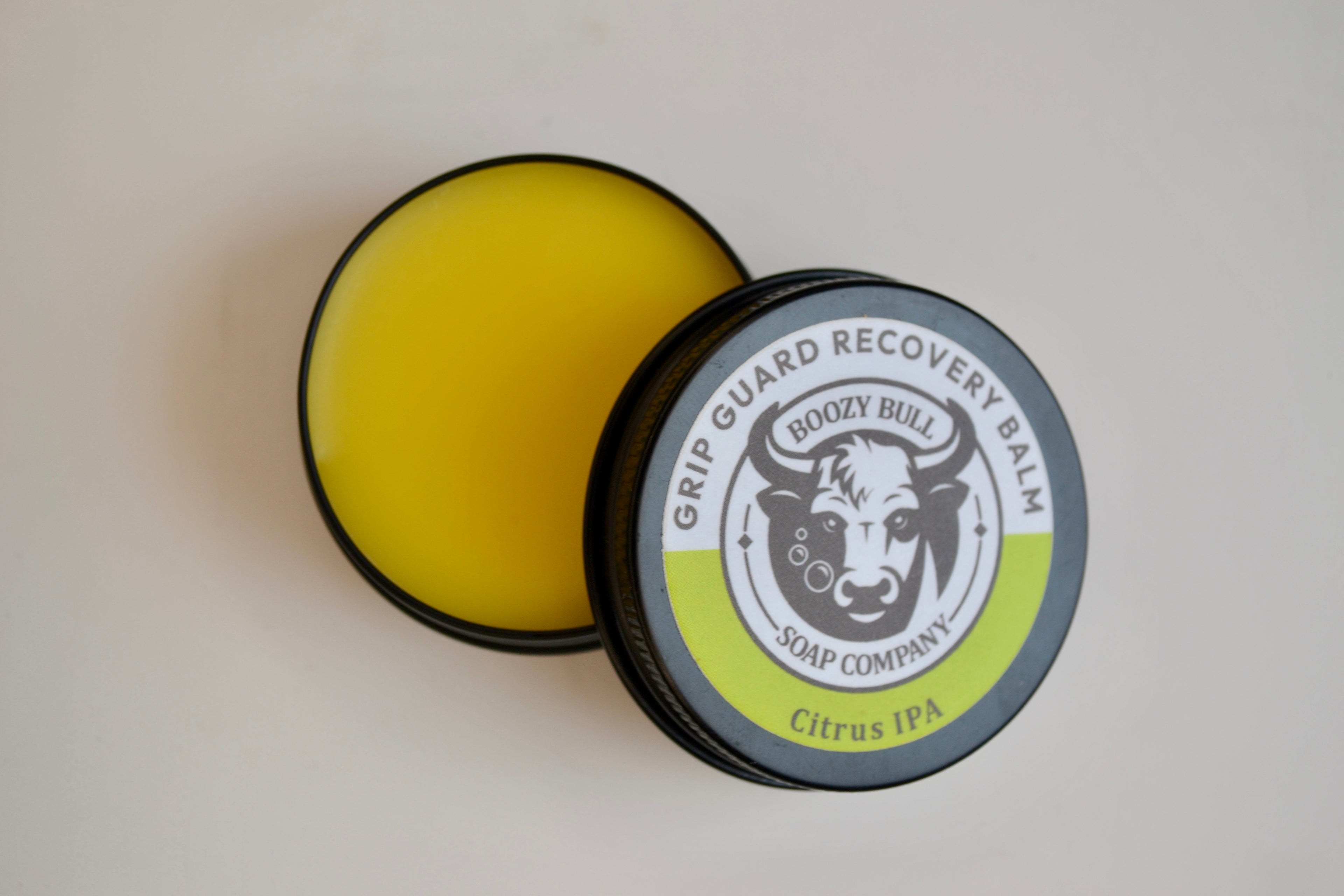Grip Guard Recovery Balm container with lid open on a white background