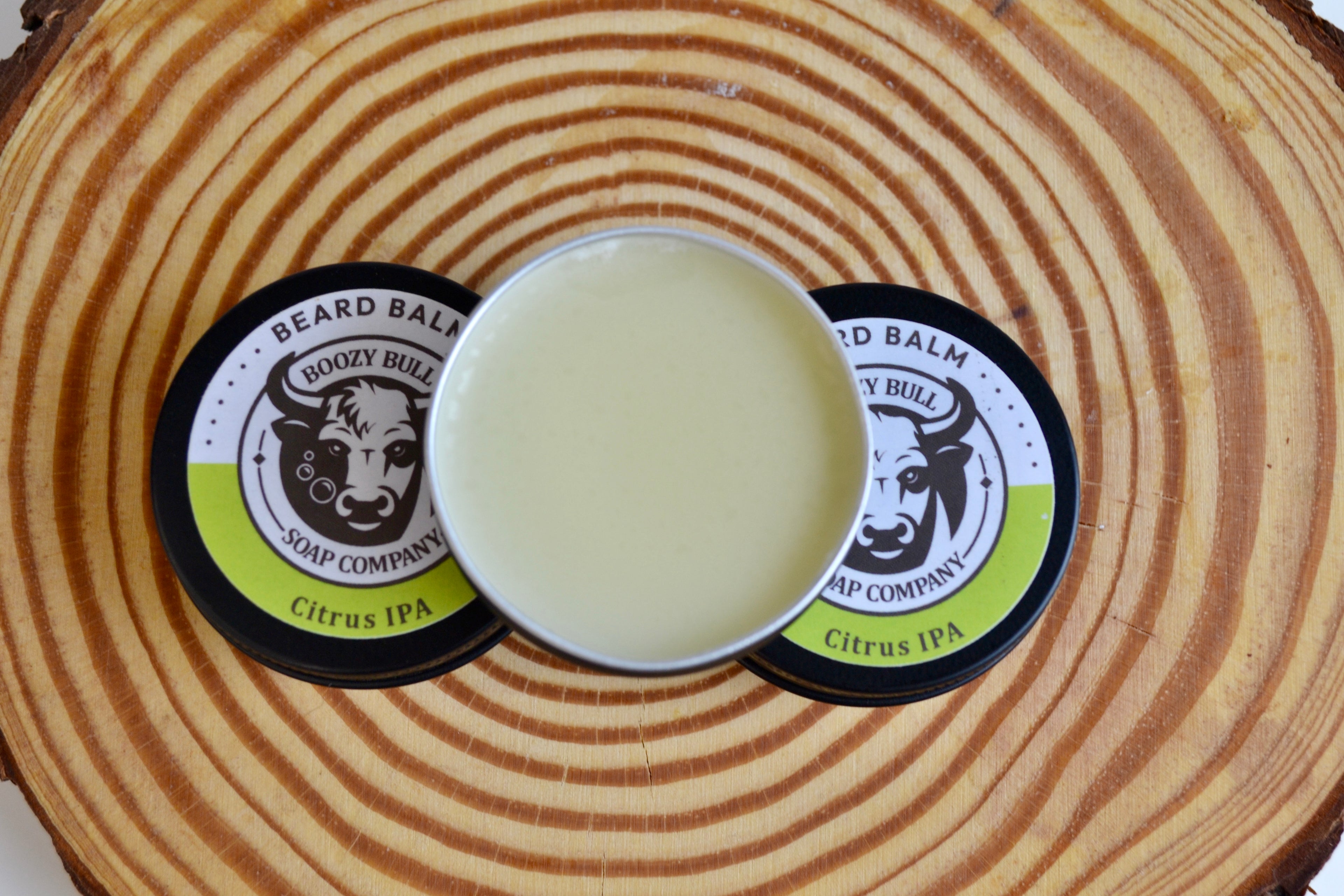 Beard balm container with circular lid on a wooden surface