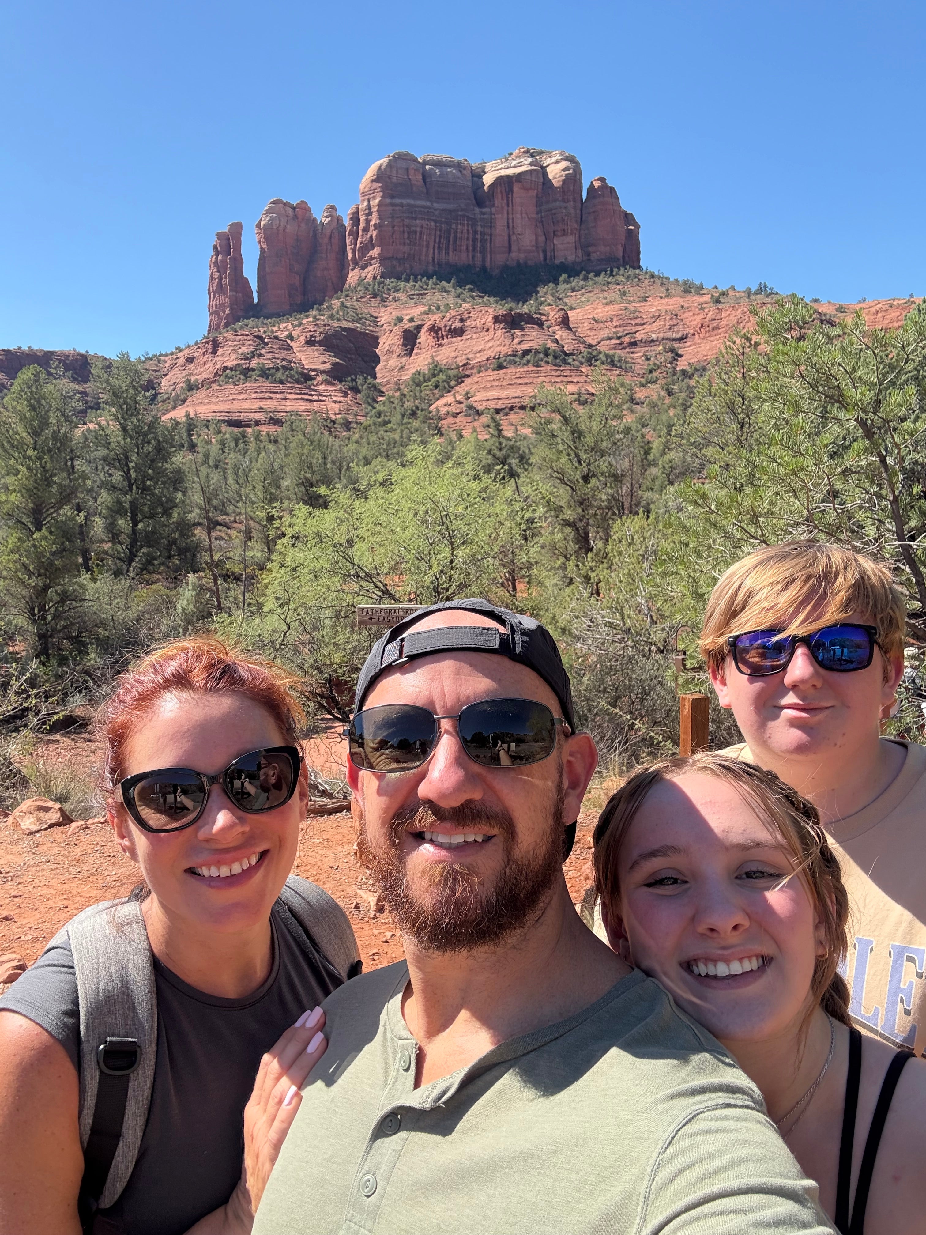Four friends taking a selfie with red rock formations in the background