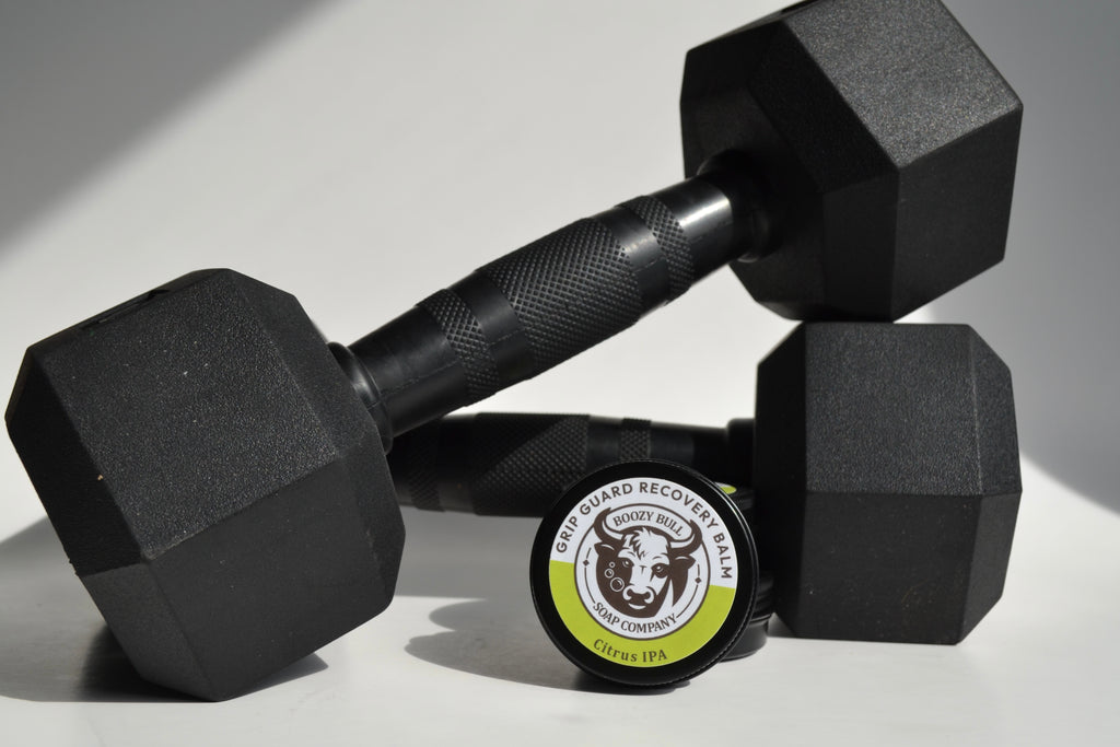 Two black hexagonal dumbbells with a circular container featuring a cow logo on a light gray background.