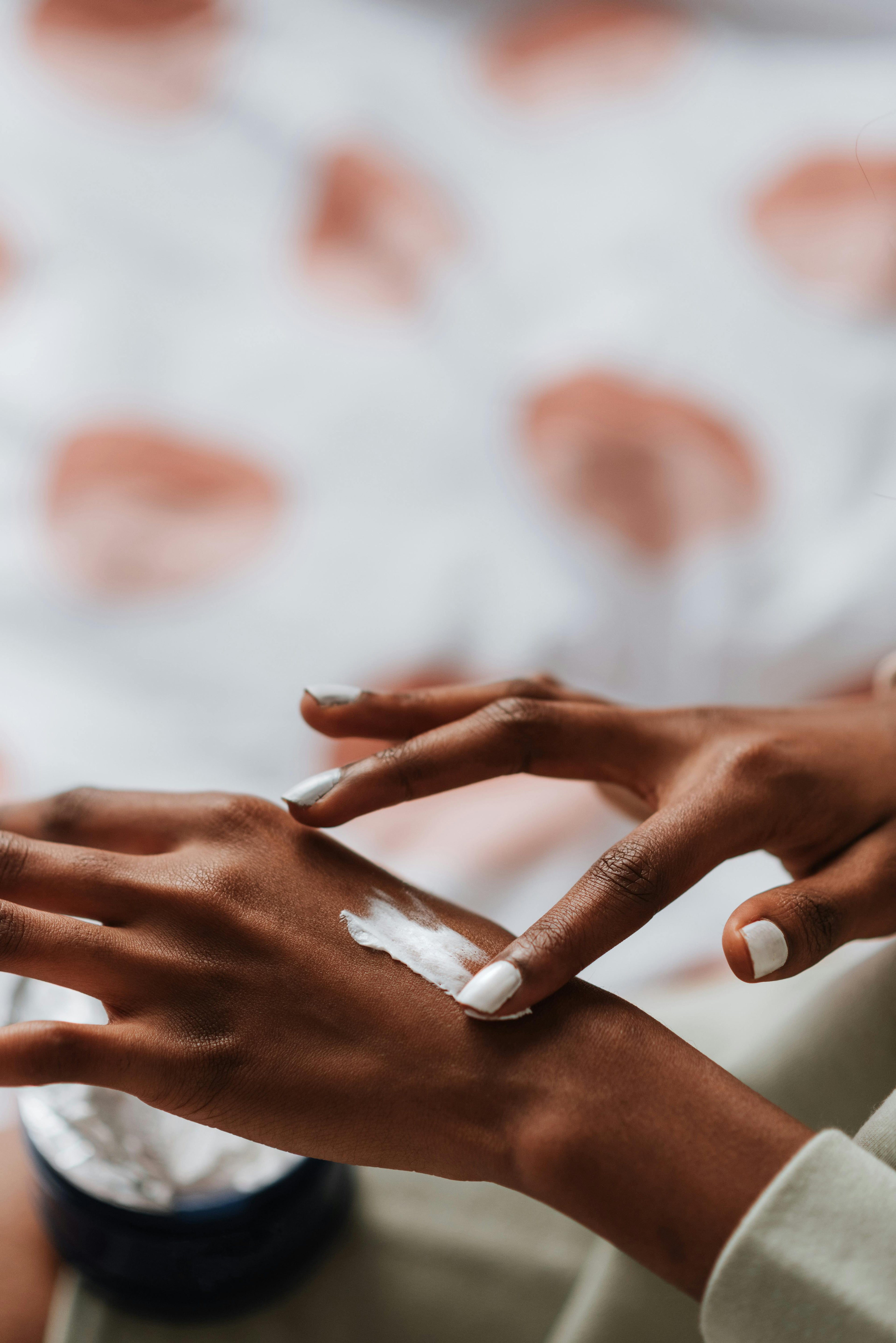 Close-up of hands putting on tallow cream with a blurred background
